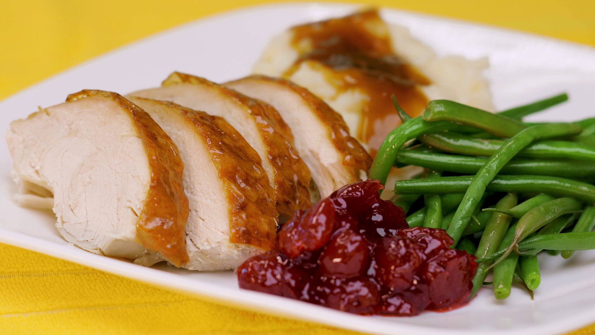 Sliced roast turkey on plate with cranberry sauce