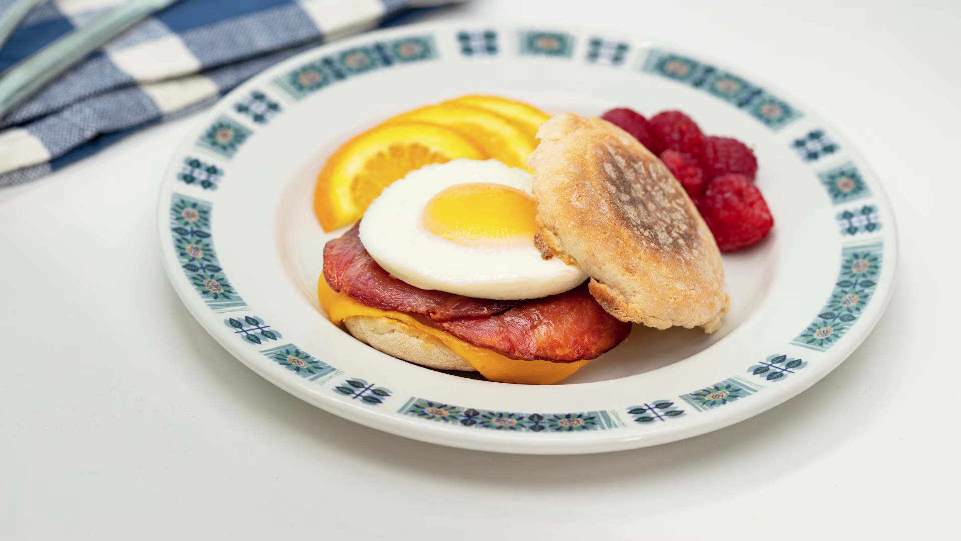 Turkey bacon and egg emglish muffin breakfast sandwich on plate