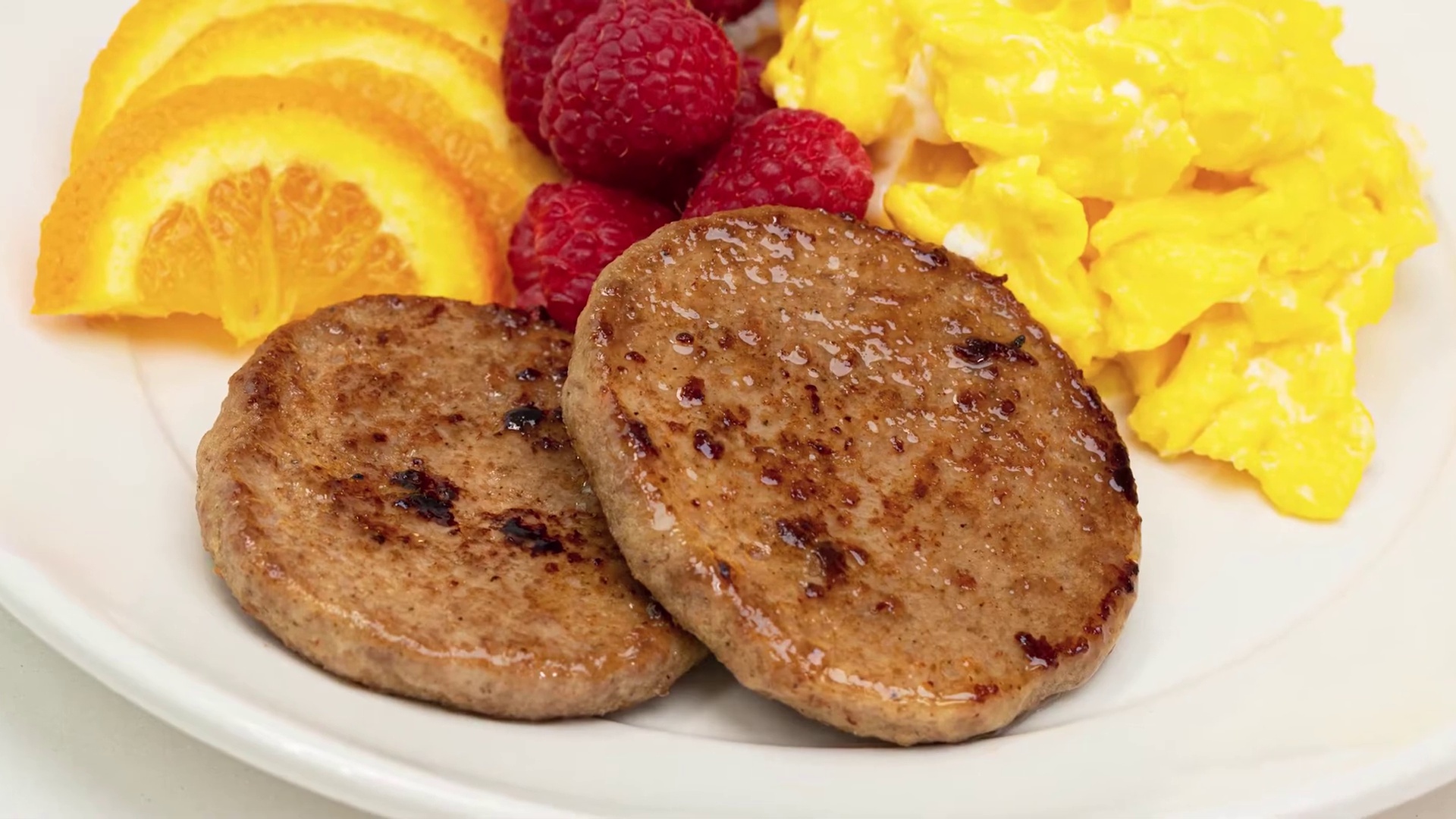 Turkey sausage rounds with scrambled eggs on plate